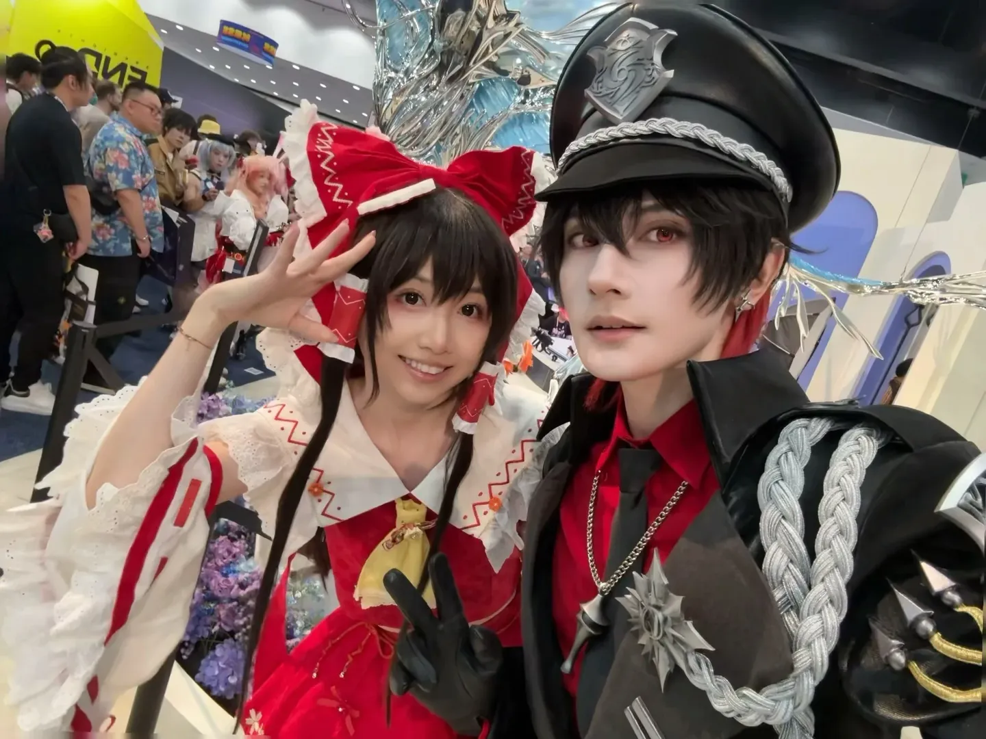 Anime Expo会場での赤白の洋装と黒い制服のツーショット写真 - 1 枚目